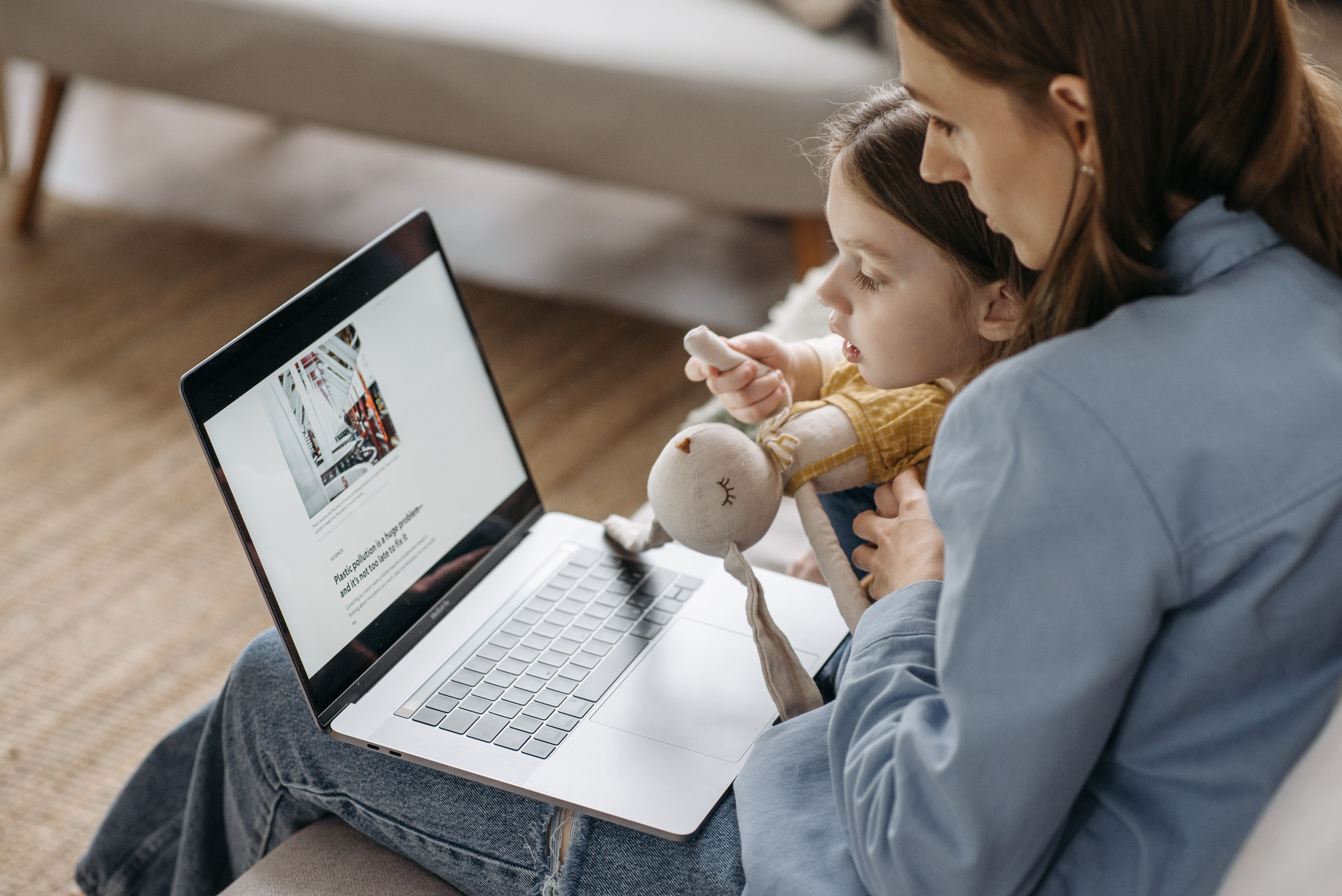 Majka radi na laptopu dok joj je dijete u krilu